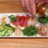 Cho xì dầu mù tạt xanh (wasabi) lên sò điệp, cá ngừ tươi và các lớp khác ở trên.