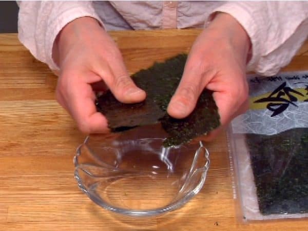 Next, tear a sheet of toasted nori seaweed into small pieces.