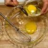 Préparez l’œuf battu pour le tonkatsu. Cassez l’œuf dans un bol. Versez la moitié de l’œuf sur un plateau. 