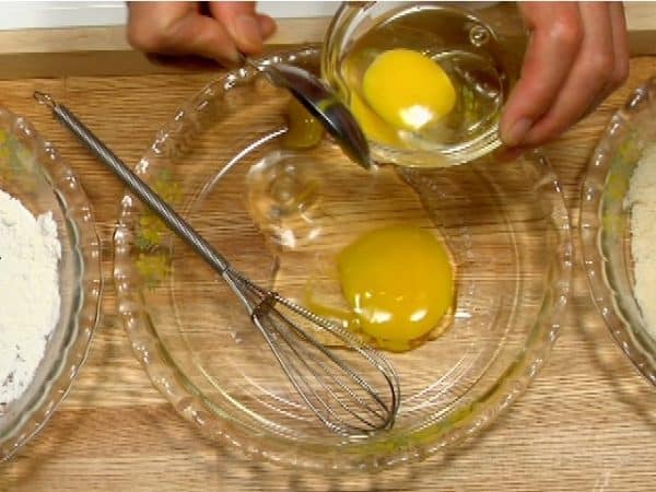 Let's make the beaten egg for tonkatsu. Crack the egg into a bowl. Pour half of the egg into a tray.