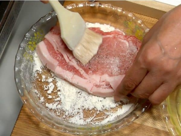 Coat both sides of the pork with flour. Shake off the excess flour.
