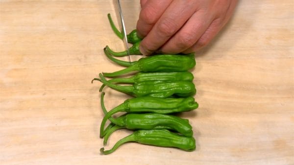 Remove the stems of the shishito peppers.