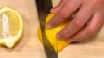 Zitrone in der Hälfte teilen und in Spalten schneiden.