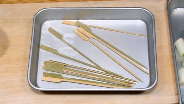 Soak the bamboo skewers in water to keep them from burning.