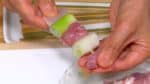 Mari buat yakitori. Tusuk daging ayam dan bawang prei dengan tusukan sate.