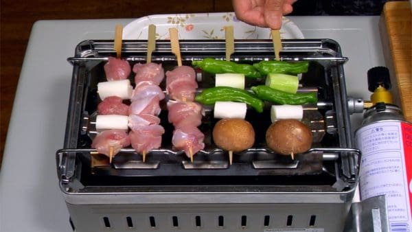 Arrange the yakitori and vegetable skewers over the burner.