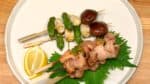 Wenn die gesalzenen Hühnchen Yakitori ohne Sauce fertig sind, ebenfalls auf dem Teller anrichten. 