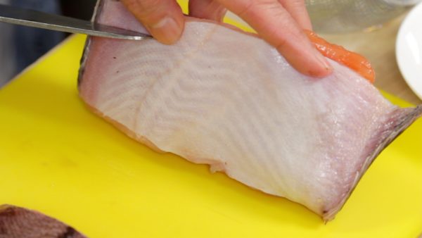 Scrape both sides of the fish with a knife, removing the scales.