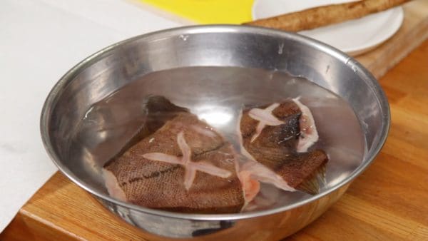 This will help to reduce the unwanted fishy flavor and make it easy to remove the remaining scales.