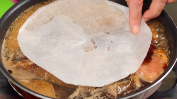 Place a sheet of parchment paper onto the karei fish and weight the paper down with a drop-lid or pie plate.