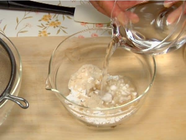 Next, let's prepare the kuzu mixture for the plain kuzumochi. Combine the kuzu starch, raw sugar and 1/3 of the water in a bowl.