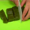 Mouillez une corne à pâtisserie pour éviter que ça colle, et coupez le kuzumochi au matcha en cubes.