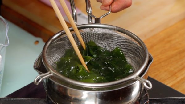 Maintenant, essorez le wakame et faites-le blanchir dans une casserole d'eau bouillante.