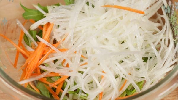 Ajoutez le daikon et la carotte dans le saladier.