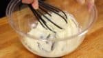 Aduk cream cheese menggunakan balon whisk.