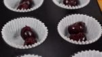 Masukan dua cherry hitam ke dalam setiap cetakan cupcake. Pastikan untuk menghilangkan air dari buah cherry dengan tisu dapur terlebih dahulu sebelum digunakan.