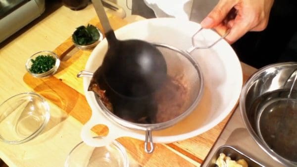 Peras sisa serpihan bonito dengan sendok. Sebagian serpihan bonito mungkin ada di dalam kaldu dashi tapi karena ini adalah sup miso, tidak perlu khawatir.
