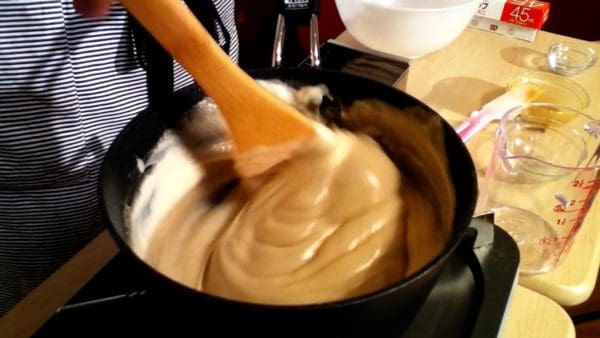 Now, the bottom is starting to harden. Stir the mixture by scraping along the bottom of the pan to prevent it from sticking. The mixture is getting thicker and thicker.