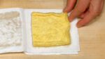 Vamos tostar o aburaage (fatias de tofu frito - encontrado em lojas de produtos orientais). Pressione o aburaage entre folhas de papel toalha para remover o excesso de óleo.