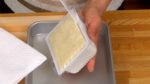 Egouttez l'excès d'eau du tofu. Retirez le bloc de tofu du paquet.