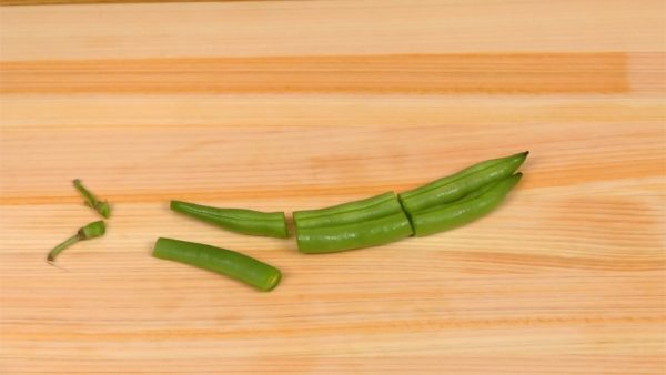 Let’s cut the vegetables. Cut the string bean pods into 3 pieces.