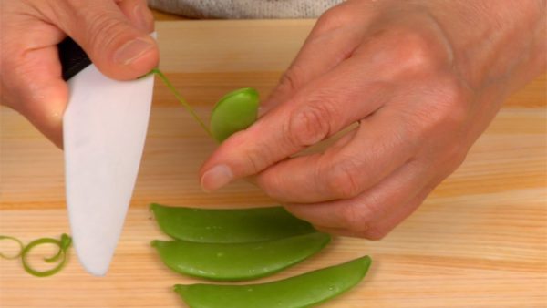 Pull off the strings from the snap bean pods.