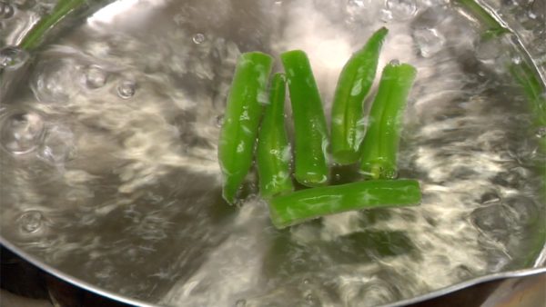 First, cook the string bean pods for 2 minutes.