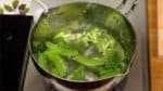 Ensuite, ajoutez les brocolis et les pois gourmands et faites cuire 1 minute de plus.