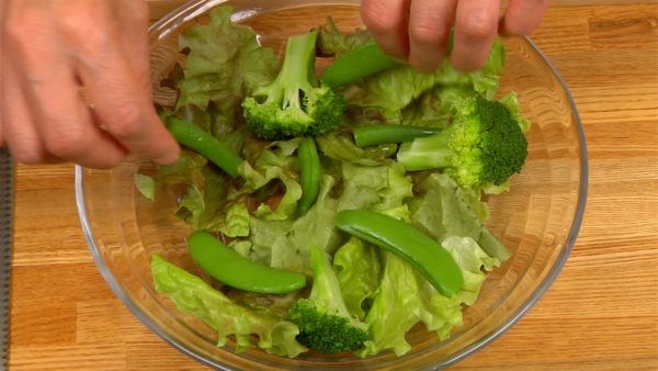 Spread the lettuce in the bowl. Place the boiled string bean pods, broccoli, and snap bean pods on the lettuce.