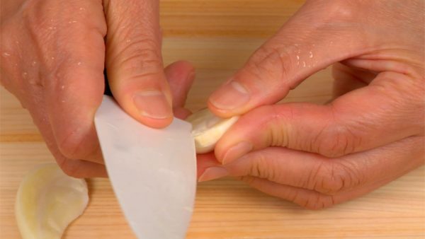 Cut the garlic clove in half and remove the root part.