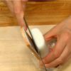 Séparez le kamaboko de sa base en bois avec le couteau.