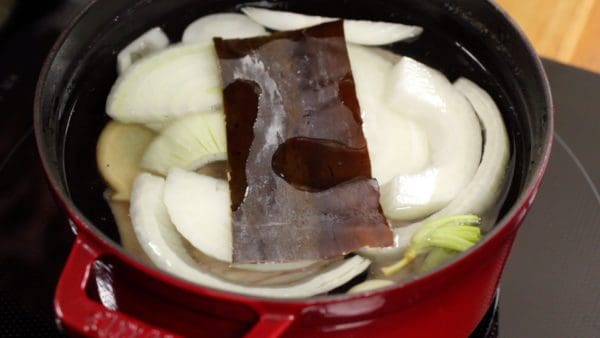 Put the aromatic vegetables and kombu into the pot.