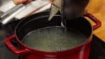 Rajoutez le bouillon égoutté du bol dans la casserole. Nous allons assaisonner le bouillon avec du nuoc mam, une sauce de poisson vietnamienne plus tard.