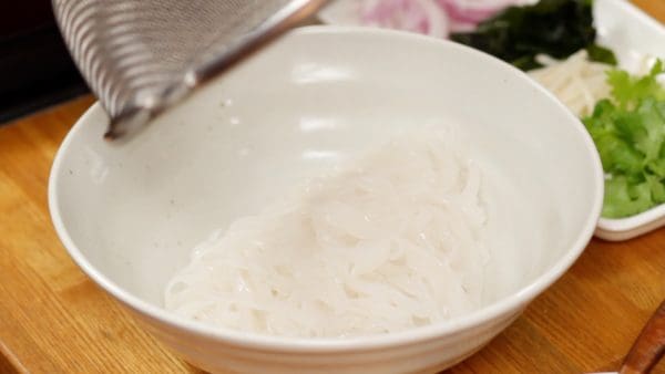 Place the noodles into a bowl. Arrange the noodles with chopsticks.