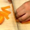 Chúng tôi sẽ cắt các nguyên liệu. Cắt cà rốt thành 4 miếng. Thái nó thành các lát mỏng.