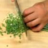 Coupez les feuilles de ciboule en trois morceaux. Coupez-les en petits morceaux.