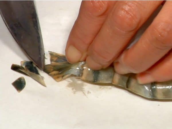 Scrape the tail with the tip of the knife to remove the moisture inside. This process will prevent the hot oil from splashing when deep-frying the prawns.