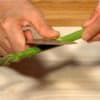 Retirez les petites écailles des asperges et coupez les tiges d'asperges en deux.