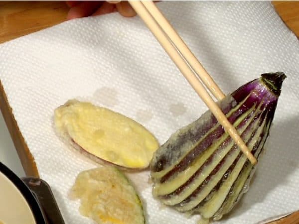 Place the vegetable tempura onto a tray covered with a paper towel.