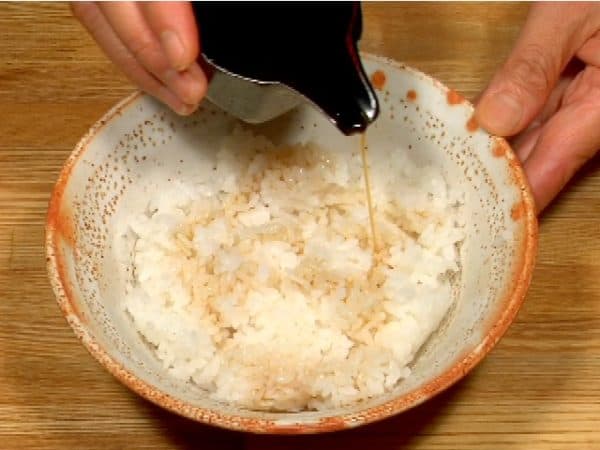 Now, pour the hot tendon sauce over the fresh steamed rice in a bowl.