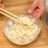 Chắt mì và rửa mì udon bằng nước đang chảy. Sau đó, ngâm chúng trong nước đá và làm lạnh mì udon.