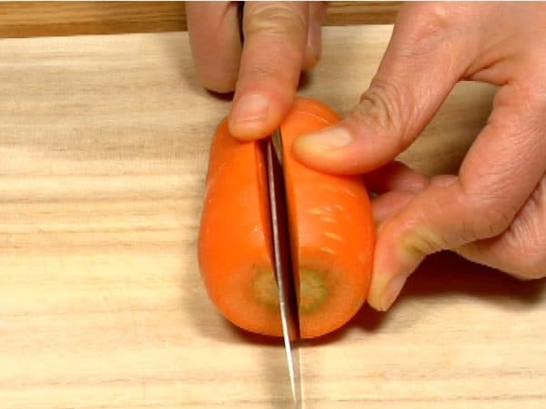 Potong dan buang bagian ujung tangkai wortel, dan potong wortel memanjang menjadi 2 bagian.