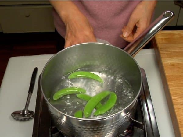 Put a pinch of salt in a pot of boiling water and cook the snap peas for about 30 seconds.