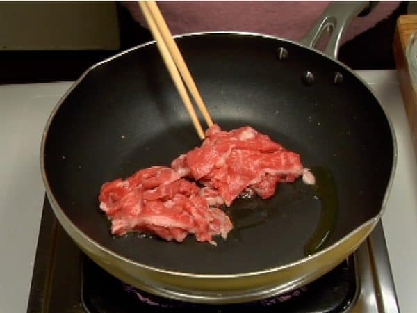 Sekarang, mari kita membuat nikujaga. Panaskan sedikit minyak sayur dalam panci dan masukkan irisan daging sapi.