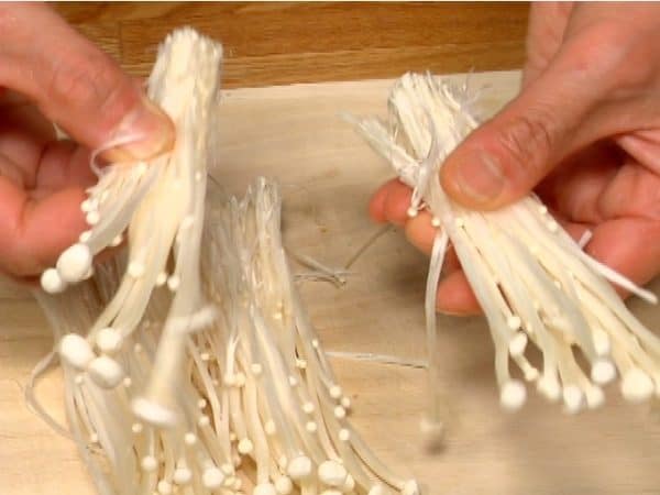 Tear enoki mushrooms into bite-size pieces.