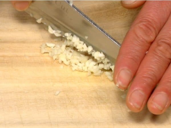 Crush the clove of garlic and chop it into fine pieces.