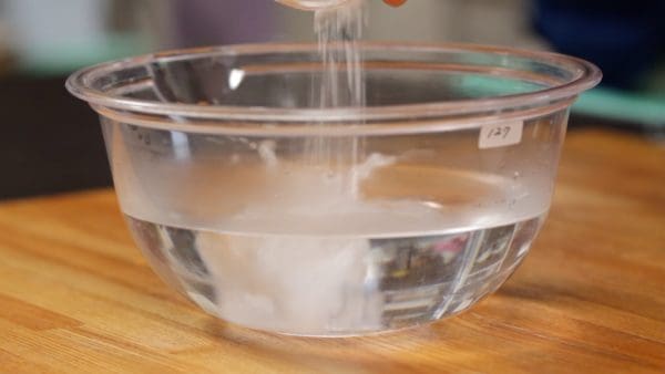 まず冷凍むきえびを解凍します。塩、重曹をぬるま湯500mlに加えて混ぜます。ぬるま湯を使うと重曹が溶けやすいです。