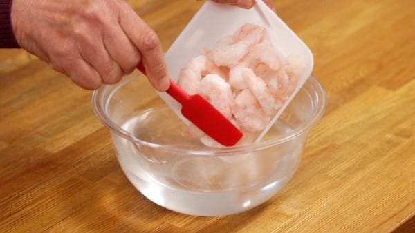 冷凍むきえびを塩水に浸けます。