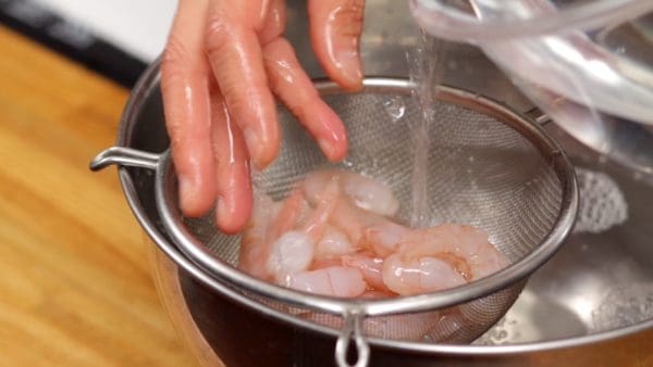 Place the shrimp into a mesh strainer and pour clean water over it.