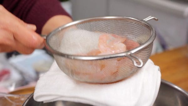 Frappez la passoire contre un torchon de cuisine à plusieurs reprises pour éliminer l'eau.